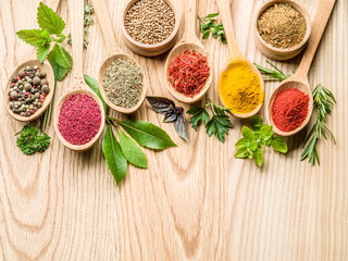 Assortment of colorful spices in the wooden spoons.