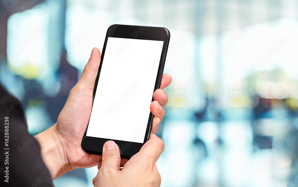 Fototapete Hand click mobile phone with blur office corridor hall way background bokeh light,White screen mock up template for adding your design or your text