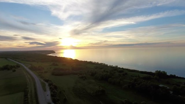 Coastal road along Gulf of Finland with beauty sunset and windless weather. Aerial view at the countryside of Estonia