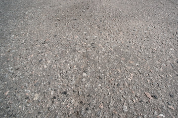 Abstract background of an old uneven asphalt