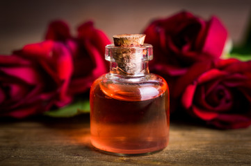 Obraz na płótnie Canvas Perfume rose on a wooden background