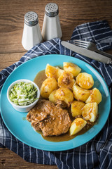 Braised meat in sauce served with boiled potatoes.