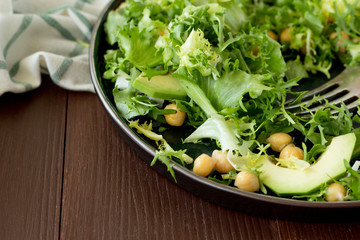 Salad with chickpea and avocado on wooden table