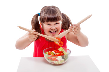 Happy girl eats healthy food, salad from fresh vegetables. Small girl is cooking, Child isolated on white background 