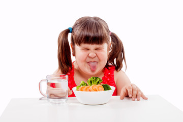 Small girl child hates healthy food. Child with fork and protruding tongue isolated on white background
