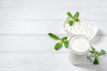 Cup of yogurt and cheese on wooden background. Flat lay with copy space for text.