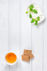 Herbal tea, cheese and waffles on the table. Copyspace for text.