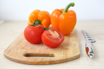 orange bell pepper, tomato on Board