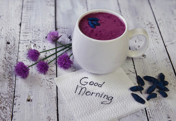 Cup of honey berry smoothy with summer flowers and good morning text 