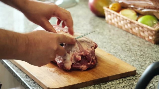The hands of the person preparing the meat for cooking in the oven
