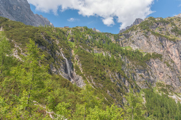 Waterfall at the foot of the mountain hut, Dolomites, Italy