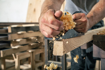 A close-up as a man is treating a black jack plane
