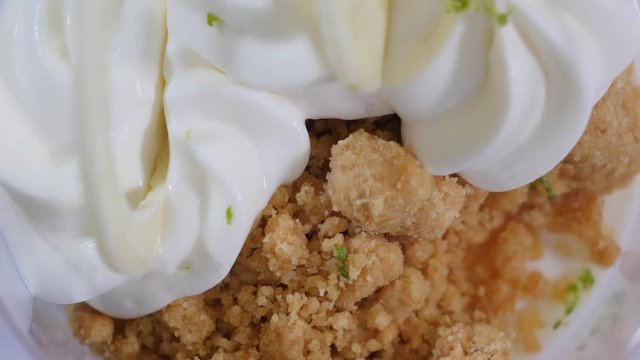 Sweet dessert in glass with biscuit, whipped cream. Ice cream with whipped cream close up