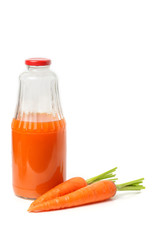 A glass bottle of carrot juice with whole carrots.