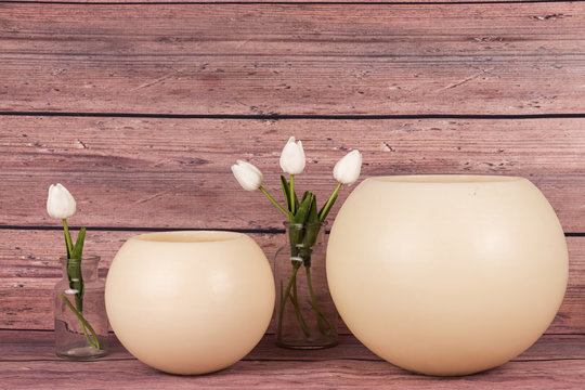 Velas grandes redondas y tulipanes blancos.