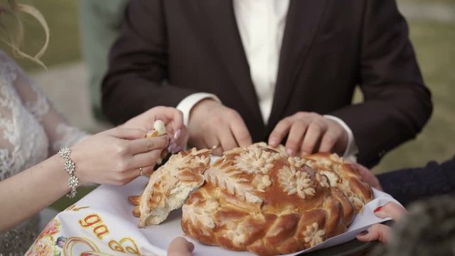 Bride and groom breaking traditional wedding bread and salt