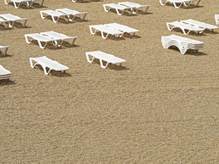 Rows of white deck chairs, sunbeds on the beach, summer vacation background. Top view