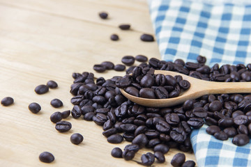 Close up coffee bean on wooden spoon and plaid napkin blue and white