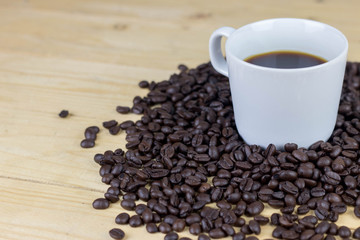 Hot coffee in white cop and coffee bean on wooden table. copy space