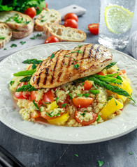 couscous salad with grilled chicken and asparagus on white plate. healthy food