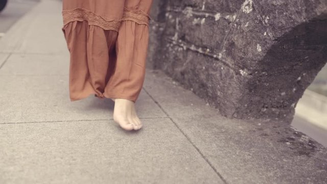 Closeup Of Woman's Bare Feet As She Walks Next To Wall At Scenic Overlook (Slow Motion)