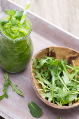 Rucola smoothie, on the grey  background.
