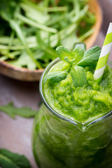 Rucola smoothie, on the grey  background.