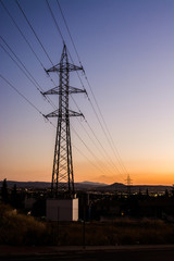 Fototapeta na wymiar Electricity tower close to an urban area against a clear sky