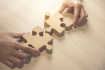 Businesswoman hand connecting jigsaw puzzle on desk, Business solutions, success and strategy...