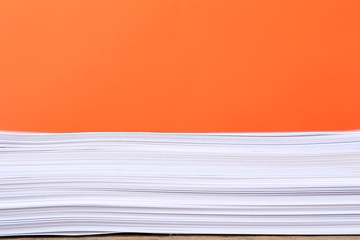 Stack of papers on orange background