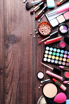 Different makeup cosmetics on brown wooden table