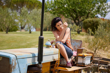Beautiful woman driving vintage tractor
