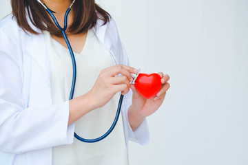 Female doctor's hands with heart and stethoscope