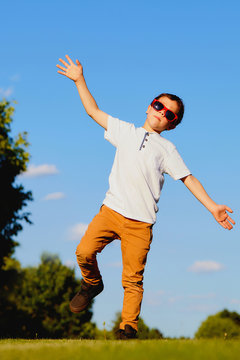 Portrait of funny boy dancing in summer park