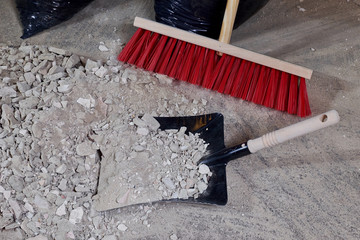 Broom and dustpan on a pile of construction rubble
