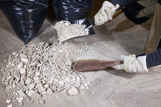 Worker Cleaning Rubble With Brush And Dustpan