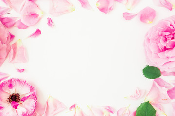Round frame of pink flowers, petals and leaves on white background. Floral lifestyle composition. Flat lay, top view.