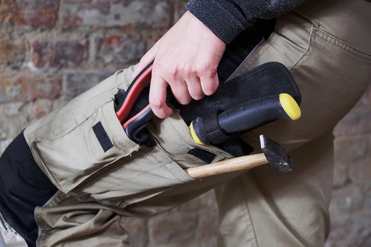 Worker wearing work pants with tools in pockets