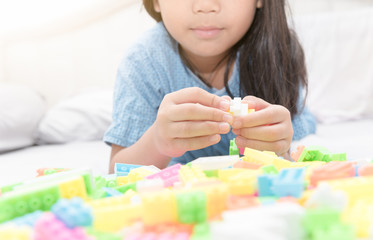 asian cute girl play block bricks on bed