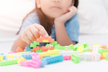 girl play block bricks on bed, education