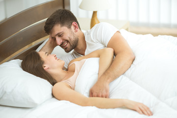 Obraz na płótnie Canvas The romantic couple lay in the bed