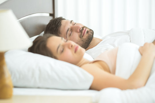 The man and woman sleeping in the comfortable bed