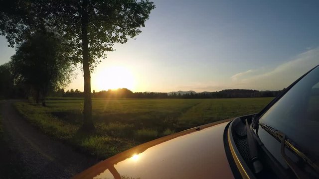 4K : Driving car at sunset sky