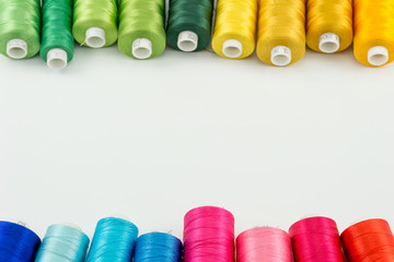 White background threads spool green yellow tone on top and blue red tone on bottom good for cover...
