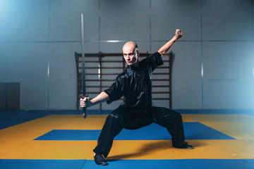 Wushu fighter with sword in action, martial arts
