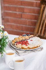 Raw vegan sweet cake with chamomile tea. Table with flowers