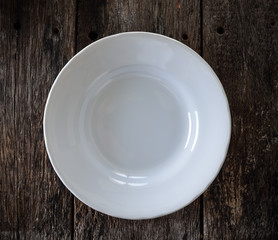 empty white plate on wooden