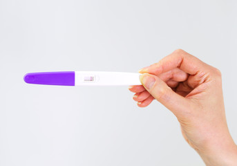 Woman holding negative pregnancy test.