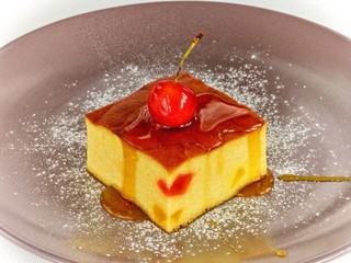 Cottage cheese casserole on a plate with cherry