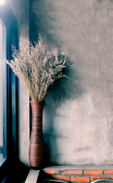 Dried flower vase in the corner of the window